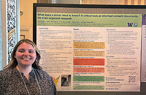 A woman poses in front of a poster