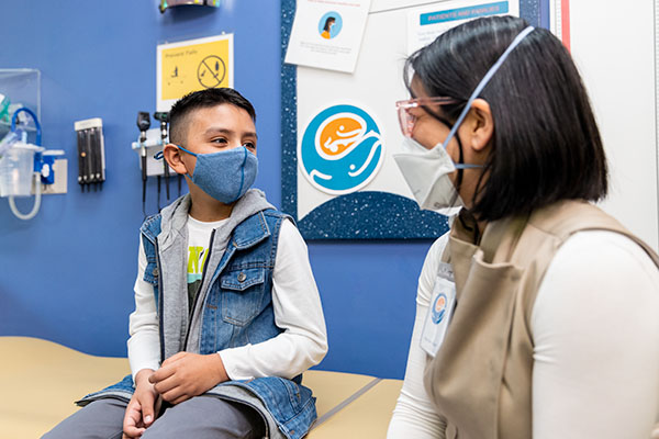 A boy speaks to a physician