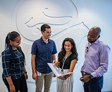 Four Seattle Children's Research Institute team members looking at a document 