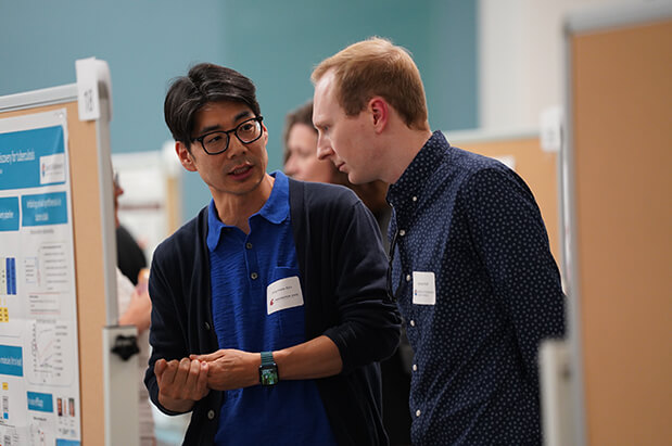 Two male researchers from Seattle Children’s and Washington State University discuss a scientific poster